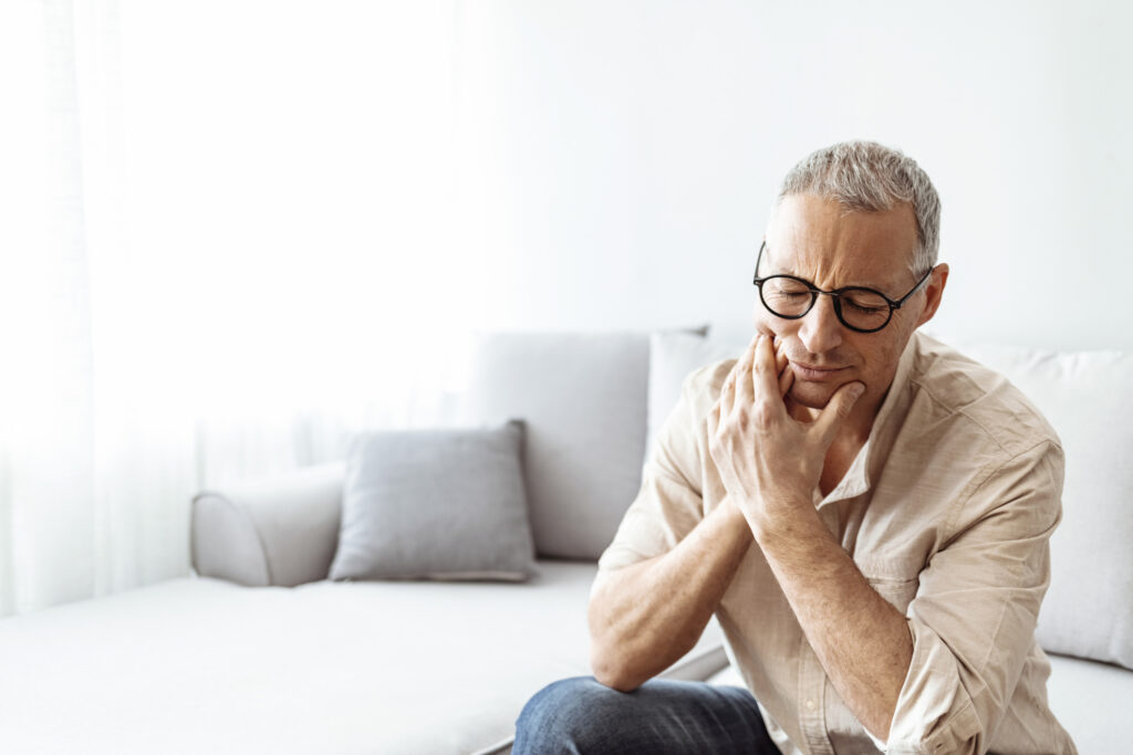Man having toothache and touching cheek. Mature man suffering from tooth pain
