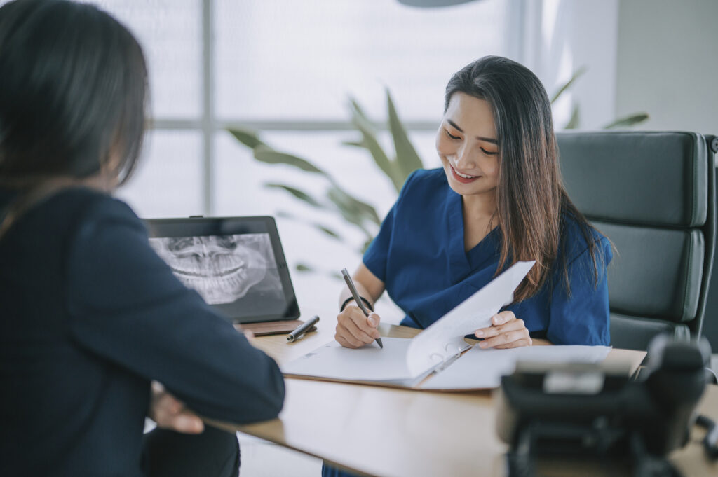 Female dentist explaining medical x-ray image To a female Patient in her office