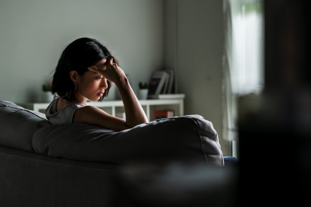 Young woman on sofa staring into space