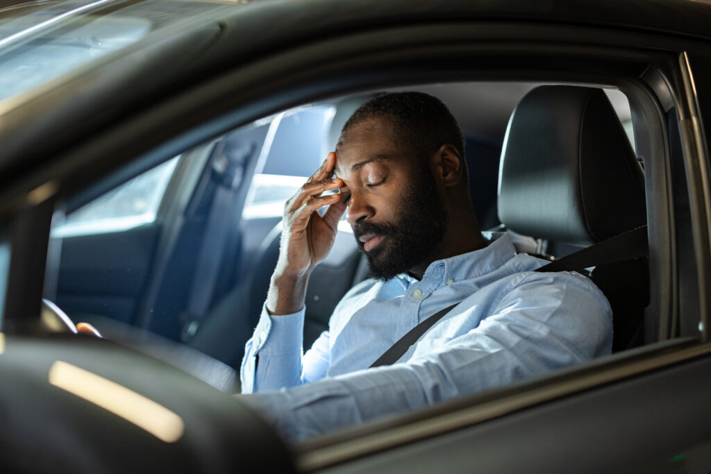 Young man in car with stressed facial expression