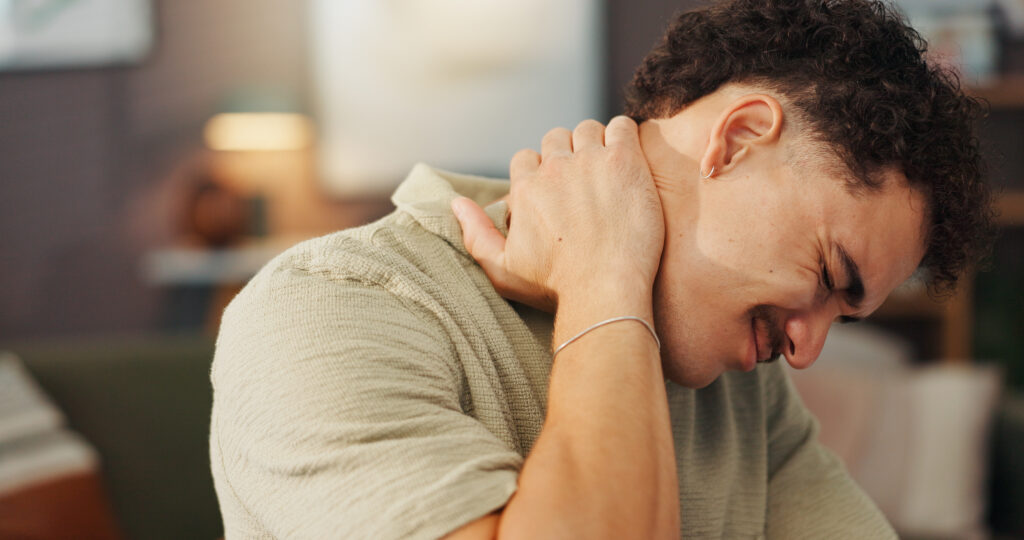 Neck pain, injury and man in home with posture problem, burnout or fibromyalgia in apartment. Muscle spasm, accident or emergency with spine inflammation, tension or pressure of ache at house